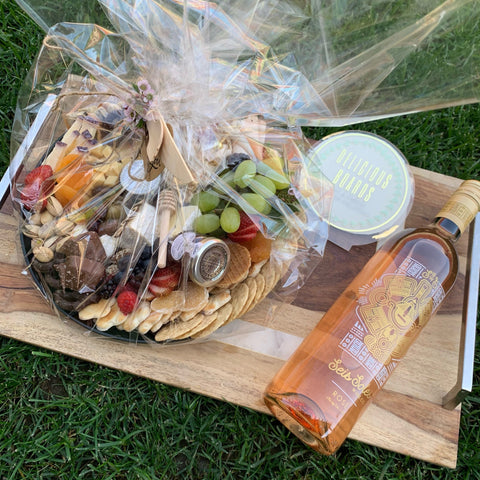 Image of 2019 Rose on board next to a basket of charcuterie.